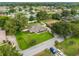 Aerial view of a well-maintained home with a green lawn, mature trees, and a white picket fence at 4360 Se 106Th St, Belleview, FL 34420
