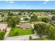 Aerial view of a well-maintained home with a green lawn, mature trees, and a white picket fence at 4360 Se 106Th St, Belleview, FL 34420