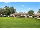 Inviting single story home with a well-maintained lawn and landscaped front yard, featuring a red front door at 4360 Se 106Th St, Belleview, FL 34420