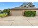 View of a three car garage with large driveway and mature landscaping at 4360 Se 106Th St, Belleview, FL 34420