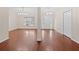 Open-concept living room with gleaming hardwood floors, neutral paint, and bright lighting fixtures at 4360 Se 106Th St, Belleview, FL 34420