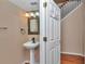 Half bathroom featuring a pedestal sink, decorative mirror, and an open doorway at 4602 Se 28Th St, Ocala, FL 34480