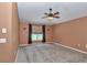 Neutral bedroom showcasing carpeted floors, large window, ceiling fan and sconce lighting at 4602 Se 28Th St, Ocala, FL 34480