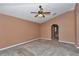 Neutral bedroom featuring carpeted floors, large window, ceiling fan and arched doorway at 4602 Se 28Th St, Ocala, FL 34480