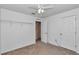A carpeted bedroom has a ceiling fan, closet and a door to another room at 4602 Se 28Th St, Ocala, FL 34480