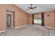 Neutral bedroom with a large window, ceiling fan, carpeted floors and open closet at 4602 Se 28Th St, Ocala, FL 34480