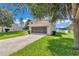 Attached garage with a screened door, long driveway, and mature landscaping at 4602 Se 28Th St, Ocala, FL 34480