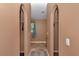 Hallway with arched doorways and tile flooring leading to a room with a window at 4602 Se 28Th St, Ocala, FL 34480