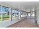 Bright sunroom with tile flooring surrounded by large windows, offering ample natural light and outdoor views at 4602 Se 28Th St, Ocala, FL 34480