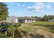 Wide backyard view with a shed, banana tree, and green grass at 4661 Sw Gardenia Ct, Dunnellon, FL 34431