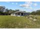 Expansive backyard with lush green grass and mature trees, perfect for outdoor activities at 4661 Sw Gardenia Ct, Dunnellon, FL 34431