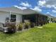 An inviting backyard features a screened lanai, fountain, decorative plants, and well-maintained lawn at 530 Casteel Ave, The Villages, FL 32163