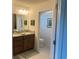 A bathroom features a granite vanity, tile floors, and an open view to the water closet at 530 Casteel Ave, The Villages, FL 32163