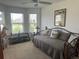 Sunlit bedroom with daybed, decorative carousel horse, ceiling fan, and large windows at 530 Casteel Ave, The Villages, FL 32163