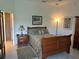 Charming bedroom features a wooden sleigh bed, neutral paint, tile flooring, and ensuite bathroom at 530 Casteel Ave, The Villages, FL 32163