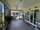 Covered and screened outdoor patio featuring seating, plants, and adjacent screened in porch at 530 Casteel Ave, The Villages, FL 32163