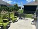 Outdoor patio featuring green furniture and a black metal table and chairs, surrounded by greenery at 530 Casteel Ave, The Villages, FL 32163