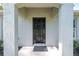 Covered front entrance with a dark front door, flanked by textured columns and lush landscaping at 5740 Nw 61St St, Ocala, FL 34482
