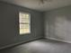 Spacious bedroom with light gray walls, wood-look tile floors, and a bright window at 6422 Nw 62Nd Pl, Ocala, FL 34482