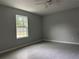 Bedroom with neutral walls, wood-look flooring, and a view from the bright window at 6422 Nw 62Nd Pl, Ocala, FL 34482