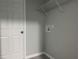Bright laundry room with gray walls, white trim, and wire shelving for storage at 6422 Nw 62Nd Pl, Ocala, FL 34482