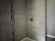 Modern shower featuring gray tiling with decorative accent strip and chrome fixtures at 6422 Nw 62Nd Pl, Ocala, FL 34482