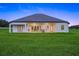Sprawling backyard featuring lush green grass and a covered patio of this stunning single-story home at 7041 Ne 22Nd Court Rd, Ocala, FL 34479