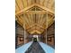 Interior shot of barn with wooden stalls, rubber mat and vehicle parked at the end at 7041 Ne 22Nd Court Rd, Ocala, FL 34479