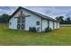 Well-maintained white barn featuring crossbuck doors, and the farm's name sign on the gable end at 7041 Ne 22Nd Court Rd, Ocala, FL 34479