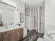 Spacious bathroom featuring a vanity, soaking tub, and separate shower with stylish wood look flooring at 7041 Ne 22Nd Court Rd, Ocala, FL 34479