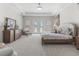 Bright bedroom featuring neutral walls, tray ceilings, plush carpet, and access to the backyard through elegant french doors at 7041 Ne 22Nd Court Rd, Ocala, FL 34479