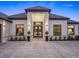 The house has a grand double door entrance framed by sconces and lush, manicured landscaping at 7041 Ne 22Nd Court Rd, Ocala, FL 34479