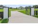 Elegant gated entrance with long drive leading to a well-manicured lawn and stunning modern farmhouse at 7041 Ne 22Nd Court Rd, Ocala, FL 34479