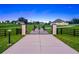 Ornate gated entrance featuring horse silhouettes and decorative posts on a vast manicured lawn at 7041 Ne 22Nd Court Rd, Ocala, FL 34479