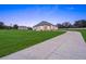 Exterior view of a modern farmhouse set on a sprawling green lawn with an extra barn at 7041 Ne 22Nd Court Rd, Ocala, FL 34479