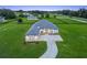 An impressive aerial view shows a modern home with a long driveway and sprawling green lawn at 7041 Ne 22Nd Court Rd, Ocala, FL 34479