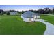 Aerial view of the home featuring modern farmhouse design, lush landscaping, and long driveway at 7041 Ne 22Nd Court Rd, Ocala, FL 34479