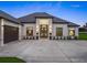 Elegant home featuring double-door entry, covered portico, and well-manicured landscaping at 7041 Ne 22Nd Court Rd, Ocala, FL 34479