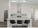 Modern kitchen with white cabinets, stainless steel appliances, a central island with bar seating, and stylish backsplash at 7041 Ne 22Nd Court Rd, Ocala, FL 34479