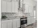 Modern kitchen showcasing white cabinets, stainless steel appliances, stylish backsplash, and sleek countertops at 7041 Ne 22Nd Court Rd, Ocala, FL 34479
