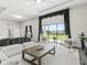Bright living room with white sofa, black accents, large windows, and a view of the fenced-in pasture at 7041 Ne 22Nd Court Rd, Ocala, FL 34479