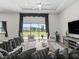 Bright living room with white sofa, black accents, large windows, and a view of the fenced-in pasture at 7041 Ne 22Nd Court Rd, Ocala, FL 34479