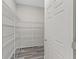 Walk-in pantry featuring an organized shelving system and wood flooring for efficient storage and easy access at 7041 Ne 22Nd Court Rd, Ocala, FL 34479