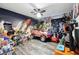 Fun, themed bedroom with a race car bed, space mural, and assorted toys at 710 Barwick St, Wildwood, FL 34785