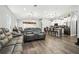 Open-concept living room with modern furnishings, hardwood floors, and seamless flow to the kitchen at 710 Barwick St, Wildwood, FL 34785