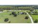 Neighborhood aerial view showcasing expansive green lawns, scattered trees, and a serene community setting in the Florida countryside at 7220 Nw 83 Ter, Ocala, FL 34482