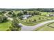 Breathtaking aerial view of the home and yard in a green, lush neighborhood, with a road leading to the property at 7220 Nw 83 Ter, Ocala, FL 34482