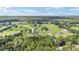 Overhead view of a rural neighborhood showcasing multiple homes and their generous land plots, interspersed with lush greenery at 7220 Nw 83 Ter, Ocala, FL 34482