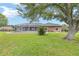 Expansive backyard features a screened-in pool, mature trees, and lush green lawn at 7220 Nw 83 Ter, Ocala, FL 34482