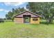 A barn with a partially enclosed stable in a grassy area with a black fence at 7220 Nw 83 Ter, Ocala, FL 34482